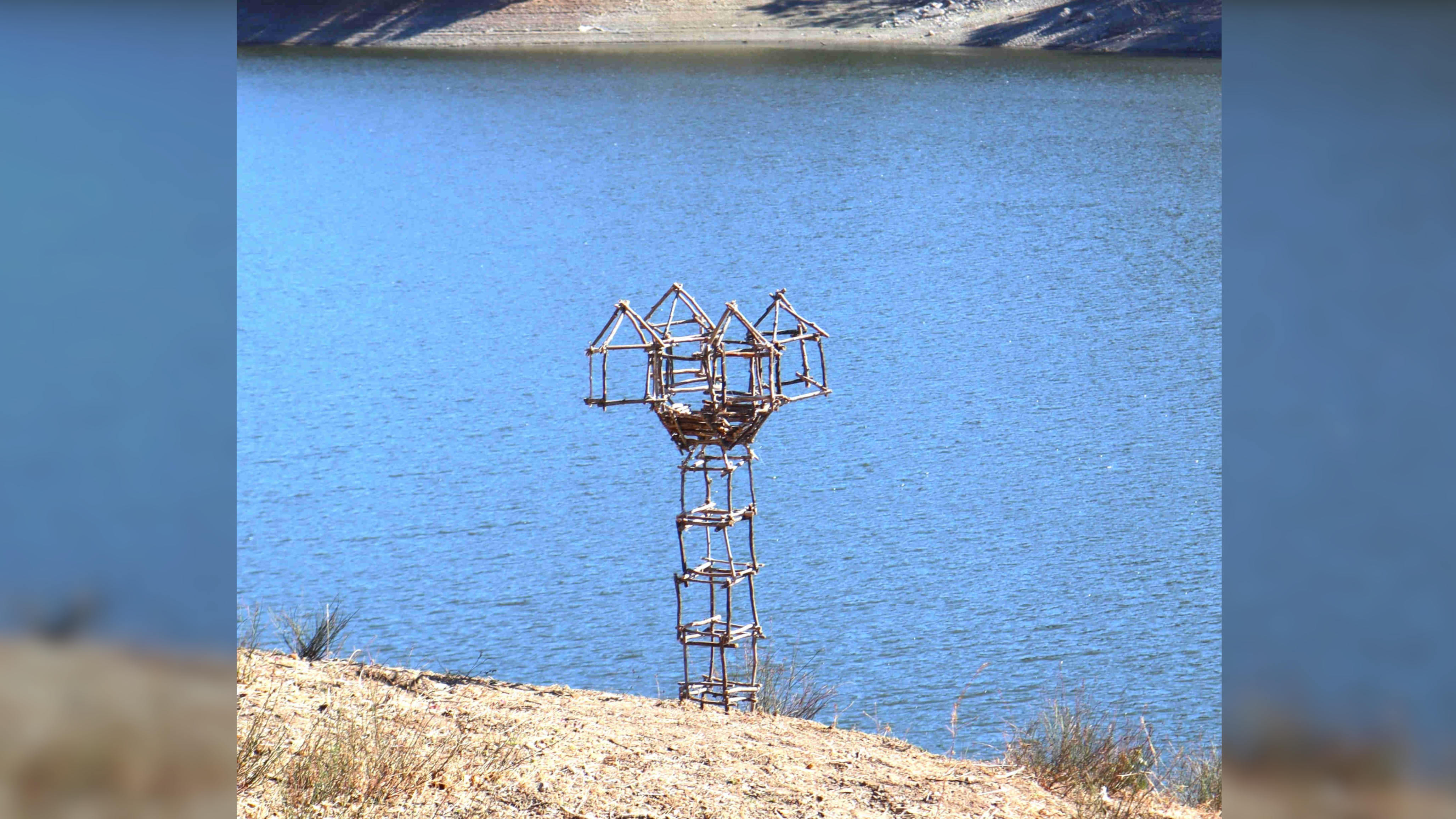 Full view of the sculpture built near a lake.
