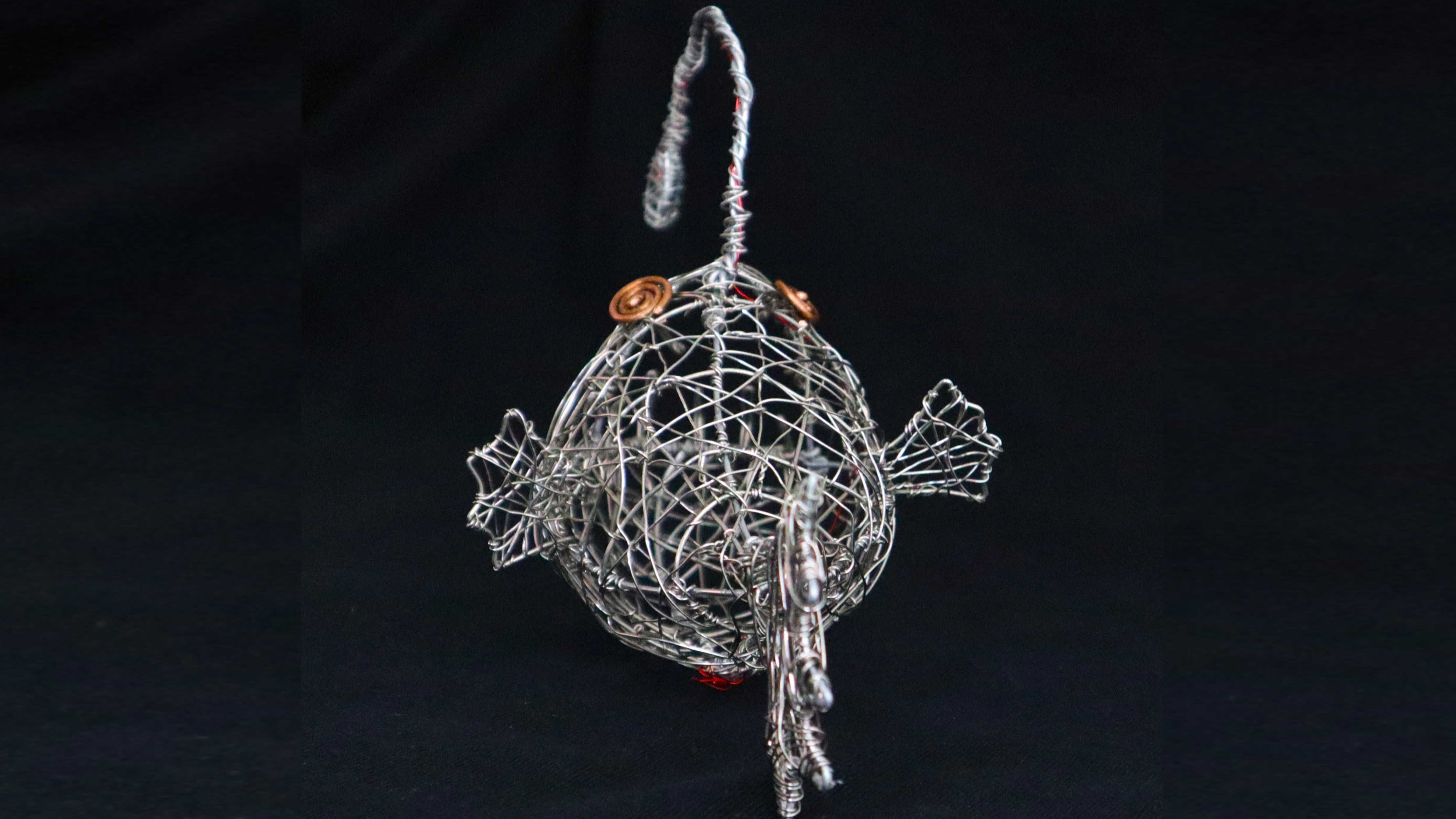 Back view of the anglerfish sculpture showing its woven wire construction.
