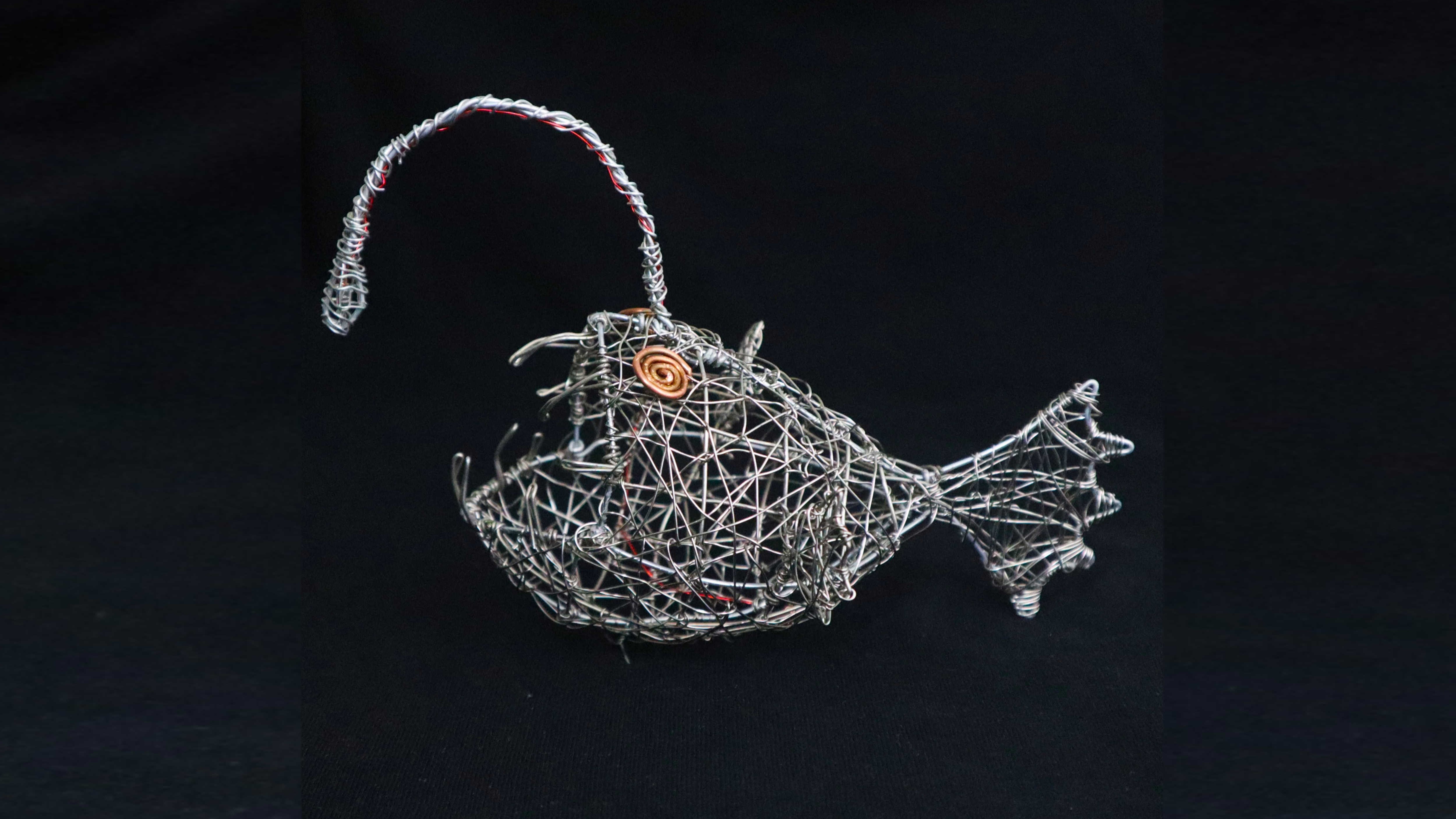 Side view of the anglerfish sculpture showing its woven wire construction.