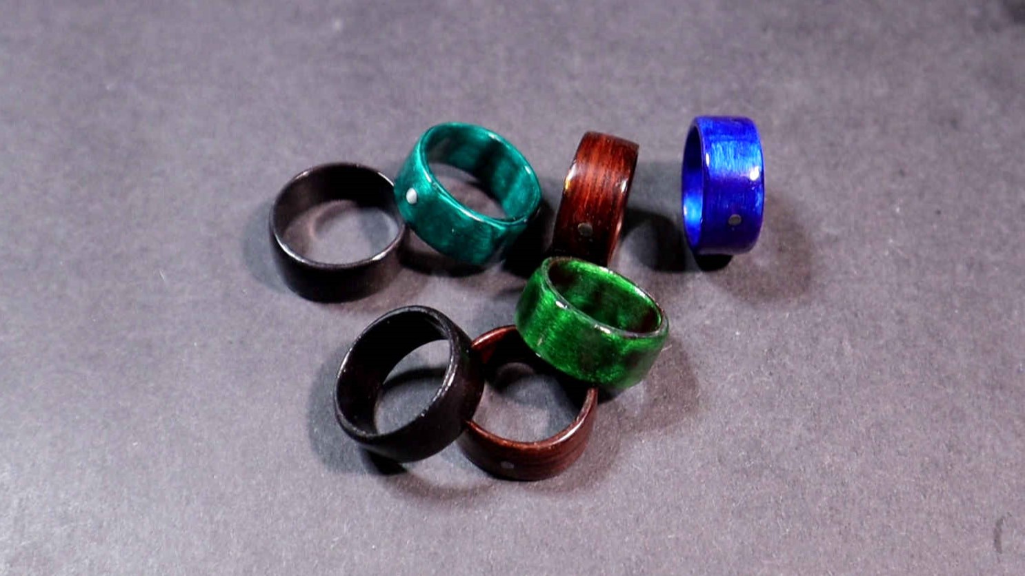 Close up picture showing rings of different colors spread out on a table.